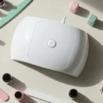 Lampa UV LED do hybryd na drewnianym blacie obok lakierów hybrydowych i narzedzi do manicure