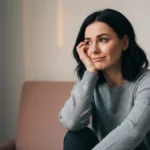 Kobieta odwracajaca wzrok z wyrazem niepewnosci, manipulacja emocjonalna w zwiazku