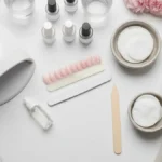 Akcesoria do manicure hybrydowego, lampa UV i kosmetyki do regeneracji paznokci na marmurowym blacie