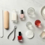 Zestaw do manicure klasycznego z lakierami, pilnikiem, oliwką i akcesoriami na marmurowym blacie