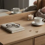 Dwie filiżanki, obrączki, notes i róże na drewnianej toaletce