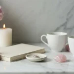 Obrączka, notes, kwiaty i dwie filiżanki na jasnej toaletce