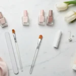 Eleganckie lakiery nude i akcesoria do subtelnego manicure biurowego na marmurowej toaletce