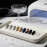 Sylwestrowy manicure z brokatem, chromem i cyrkoniami na marmurowej toaletce