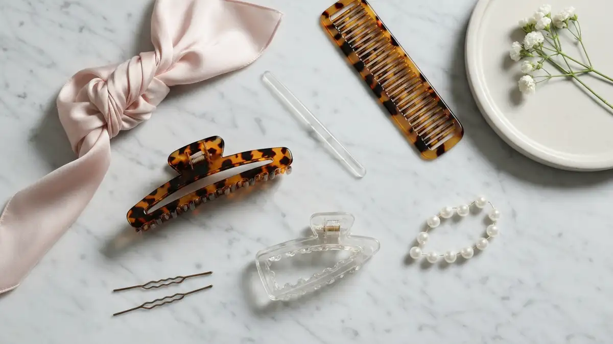 Eleganckie spinki claw clip na marmurowej toaletce z grzebieniem, jedwabiem i kwiatami